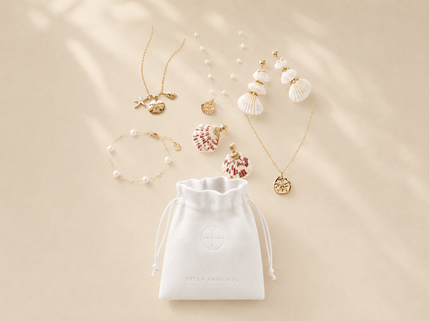 Jewelry set with necklaces, bracelets, and a drawstring bag on a beige background