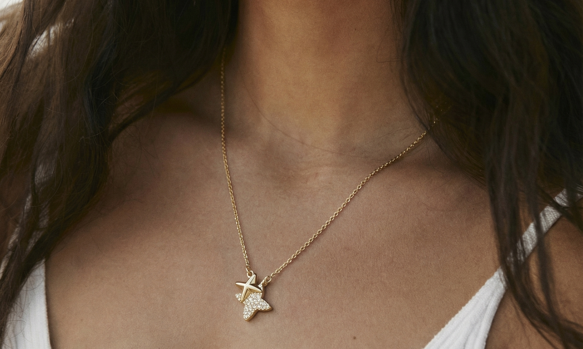 Close-up of a woman wearing a gold necklace with a star pendant.