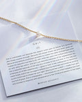 grit necklace in gold on with description card
