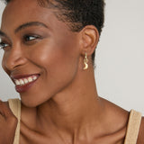 Model wearing Sun Moon & Stars Huggies in 14k gold finish