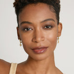 Model wearing Sun Moon & Stars Huggies in 14k gold finish