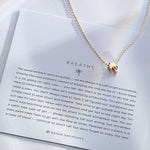 Breathe Necklace showcase in 14k gold on card