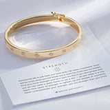 Strength Hinged Bracelet showcase in 14k gold on card