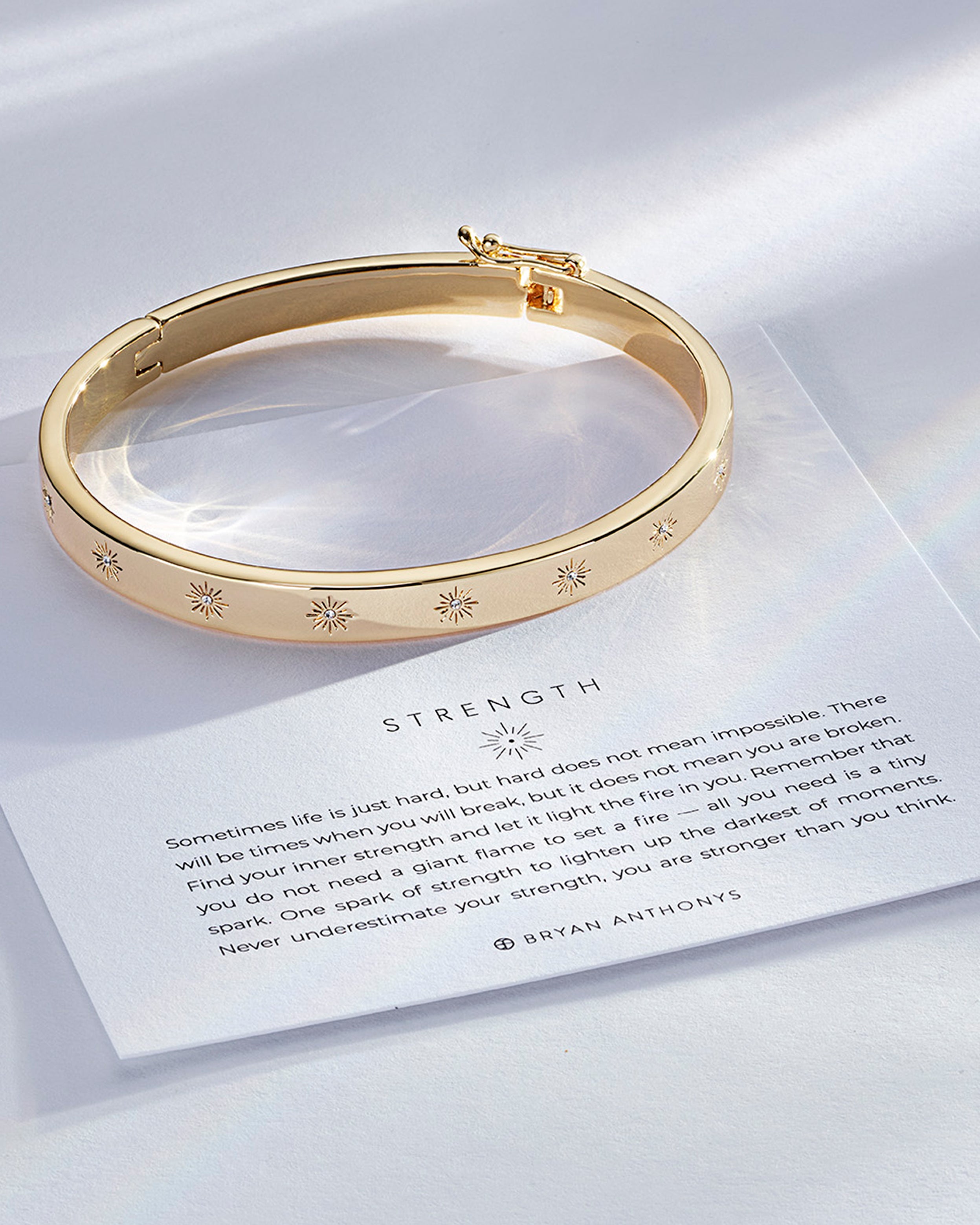 Strength Hinged Bracelet showcase in 14k gold on card